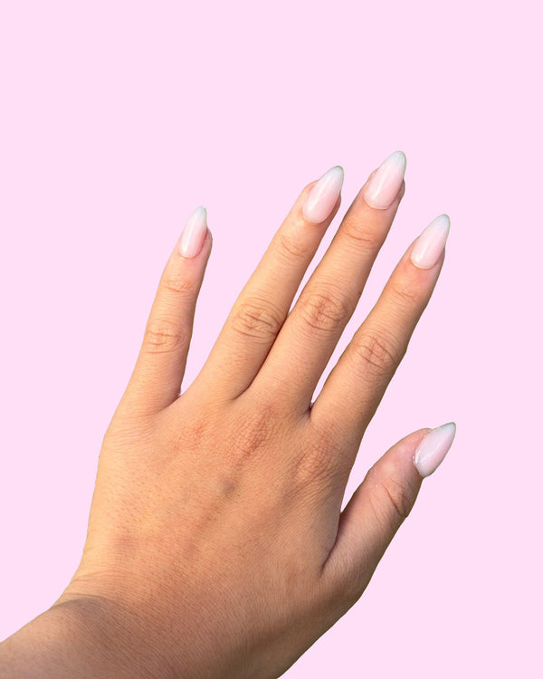 Milky Pink BIAB press on nails worn on hand, almond shape - Aurelle Beauty