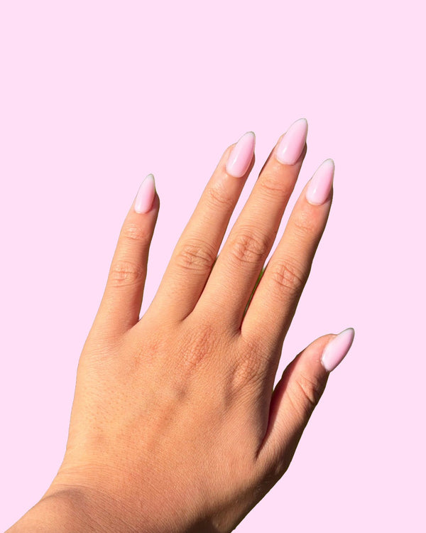 Soft Pink BIAB press on nails worn on hand, almond shape - Aurelle Beauty